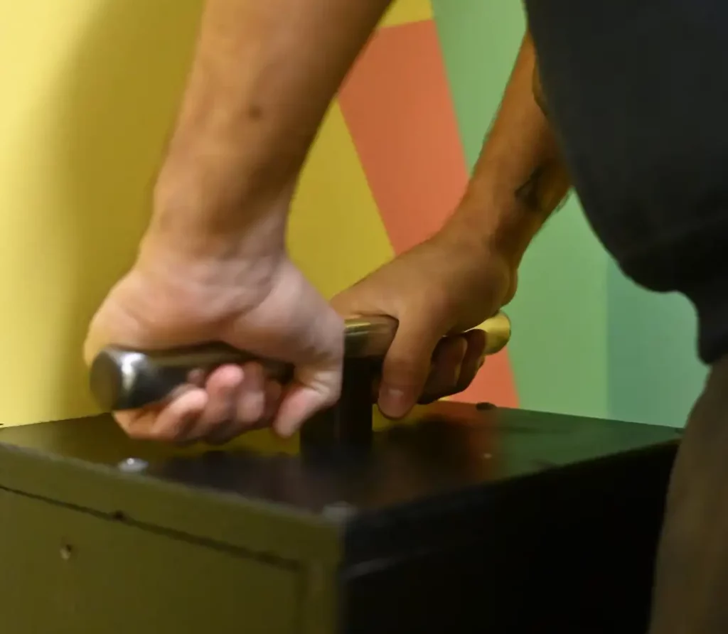 A man’s two hands pushing down a lever