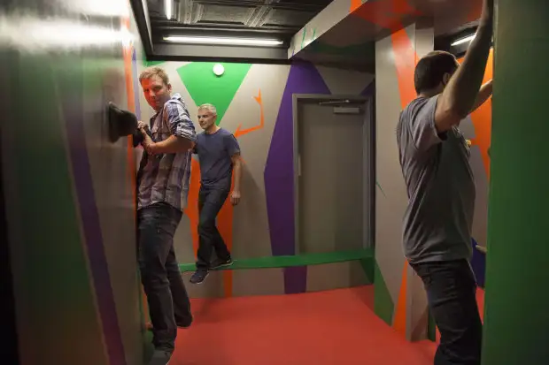 Three guys climbing on colorful walls