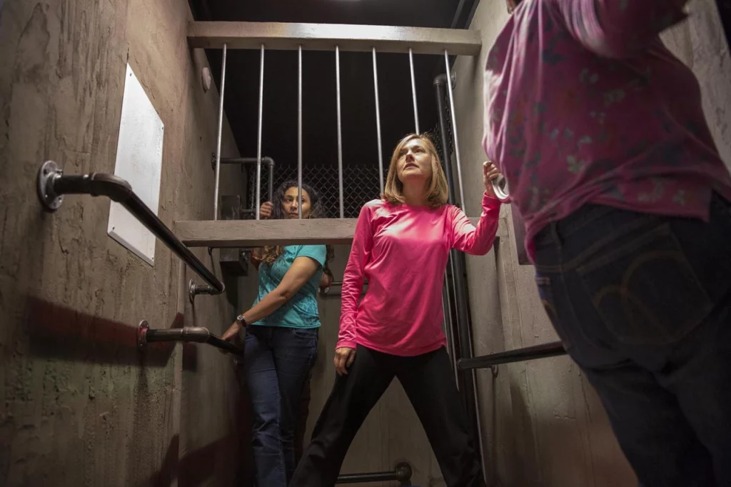 Three woman walking through pipes