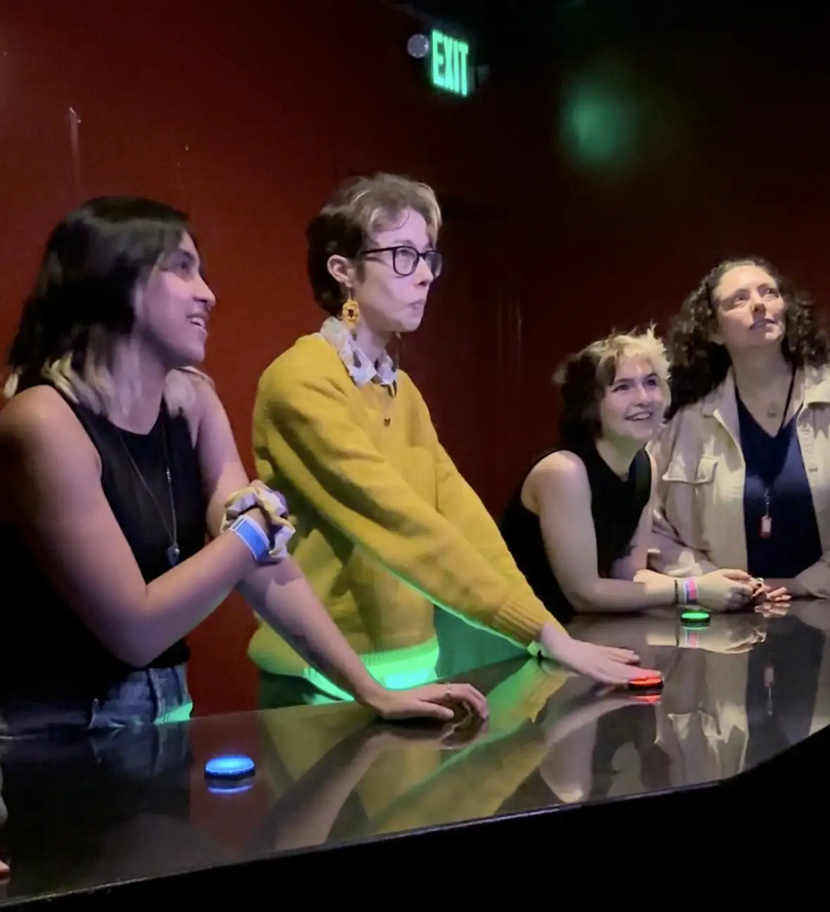 4 friends hitting buttons on a table