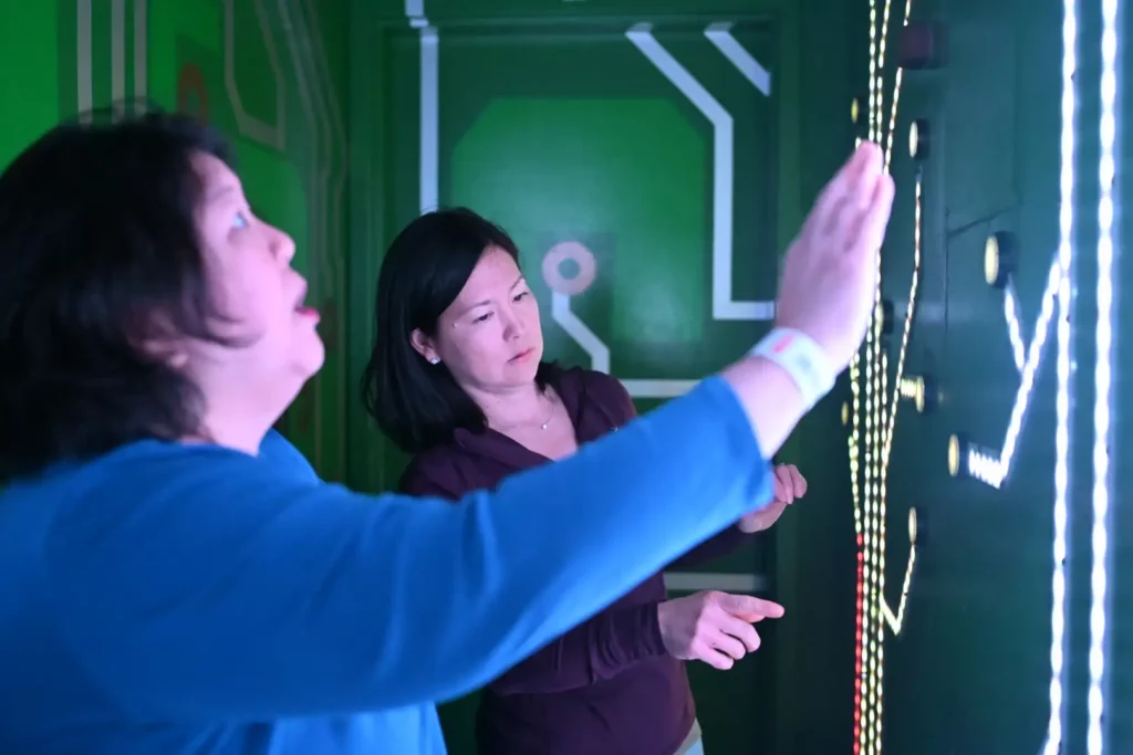 Two woman looking at lights on a wall